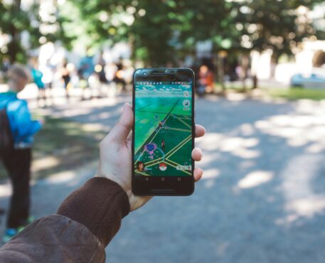 a hand holding a cell phone with Pokemon Go